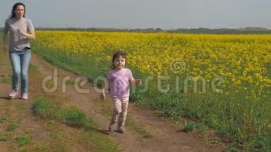一个有孩子的女人在大自然中玩耍。 一个幸福的家庭正在新鲜的空气中奔跑。 一个带着孩子的女孩沿着一个乡村